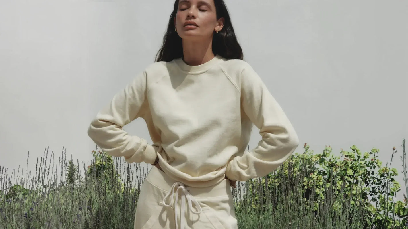 Woman wearing a cream-colored outfit standing in a field of lavender.